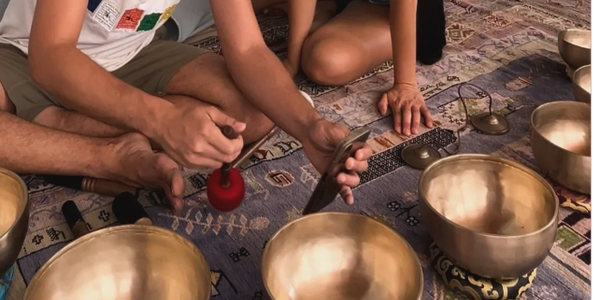 dos personas tocando cuencos tibetanos