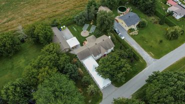Aerial view of residential houses surrounded by greenery and roads.