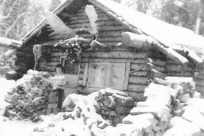 Betty Idleman VanDevere stands in front of her cabin (from Redoubt Reporter 6/2010)