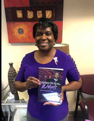 Woman in purple holds a book titled Inspirational Words.