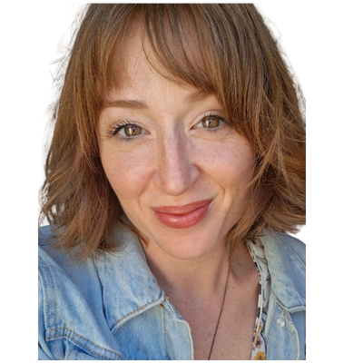 Smiling woman with light brown hair and a denim jacket.