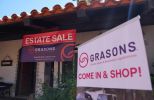 Estate sale and Grasons shop signs outside a building.
