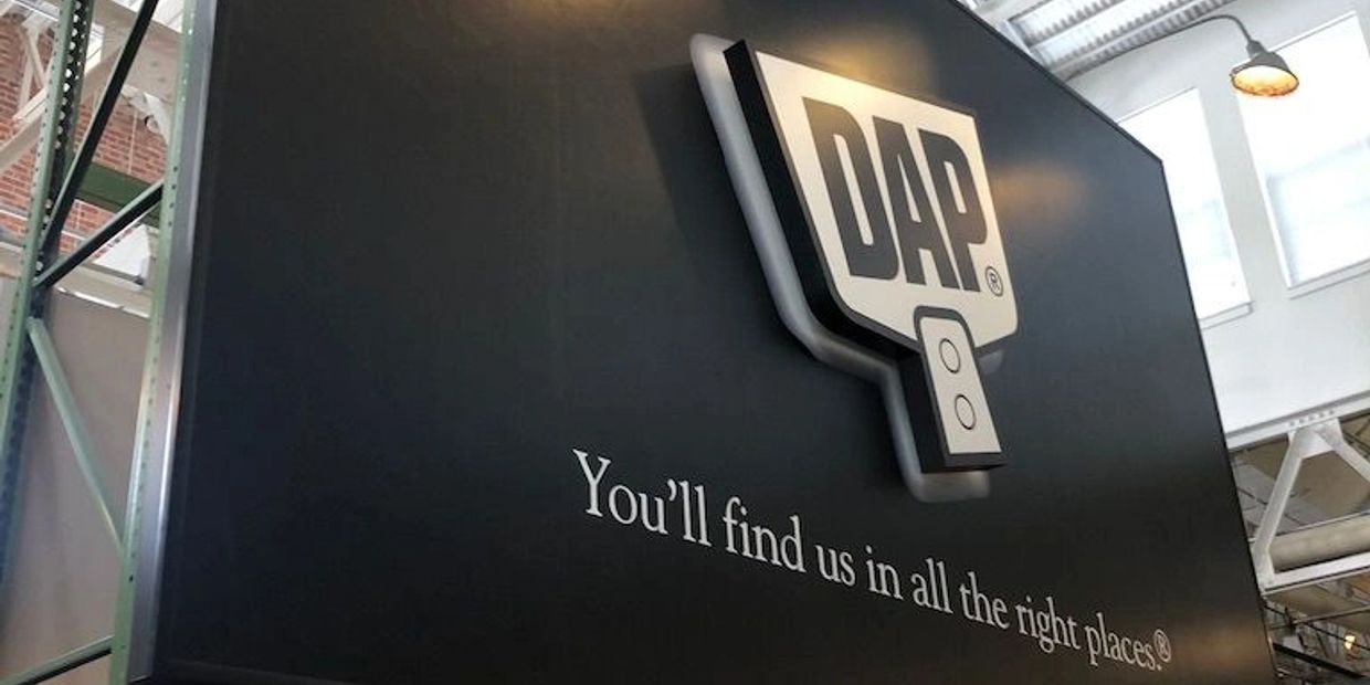 DAP sign with slogan on a black wall.