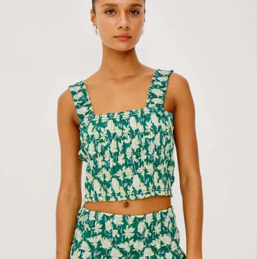 Woman wearing a green floral crop top and matching bottoms.