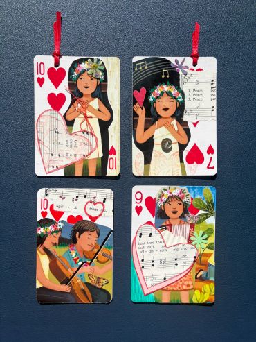 Four decorated heart-themed playing cards with musical and floral designs.