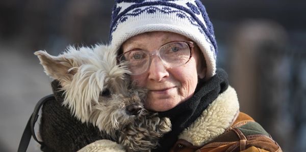 Older lady holding a dog in winter