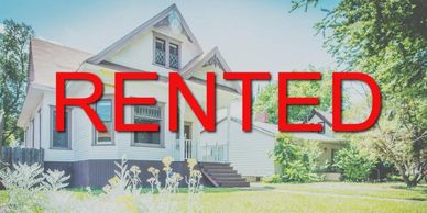 A white house with a large red "RENTED" sign over it.