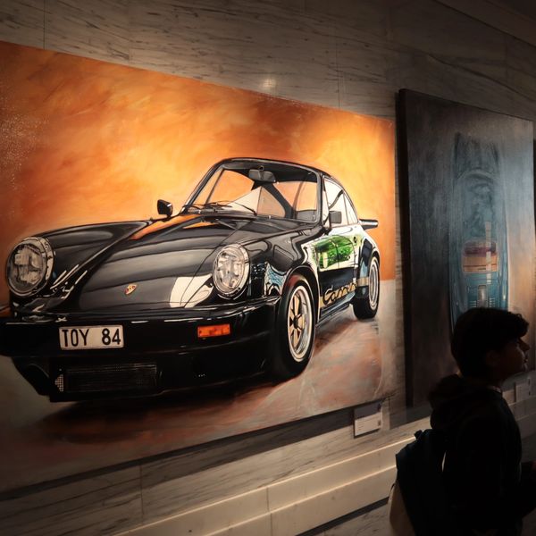 A realistic painting of a black Porsche Carrera 911 with license plate TOY 84.