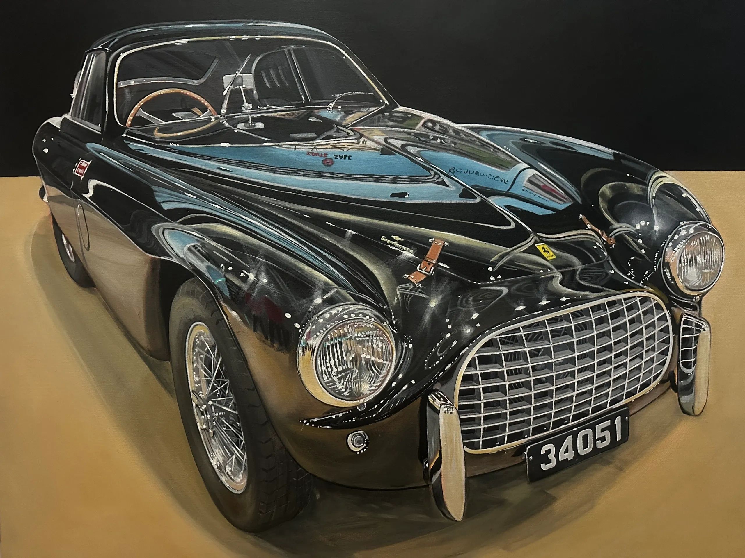 A glossy black vintage car with a wooden steering wheel and chrome details.