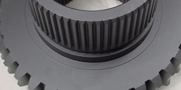 Close-up of a gray industrial gear with fine teeth and a central hub.