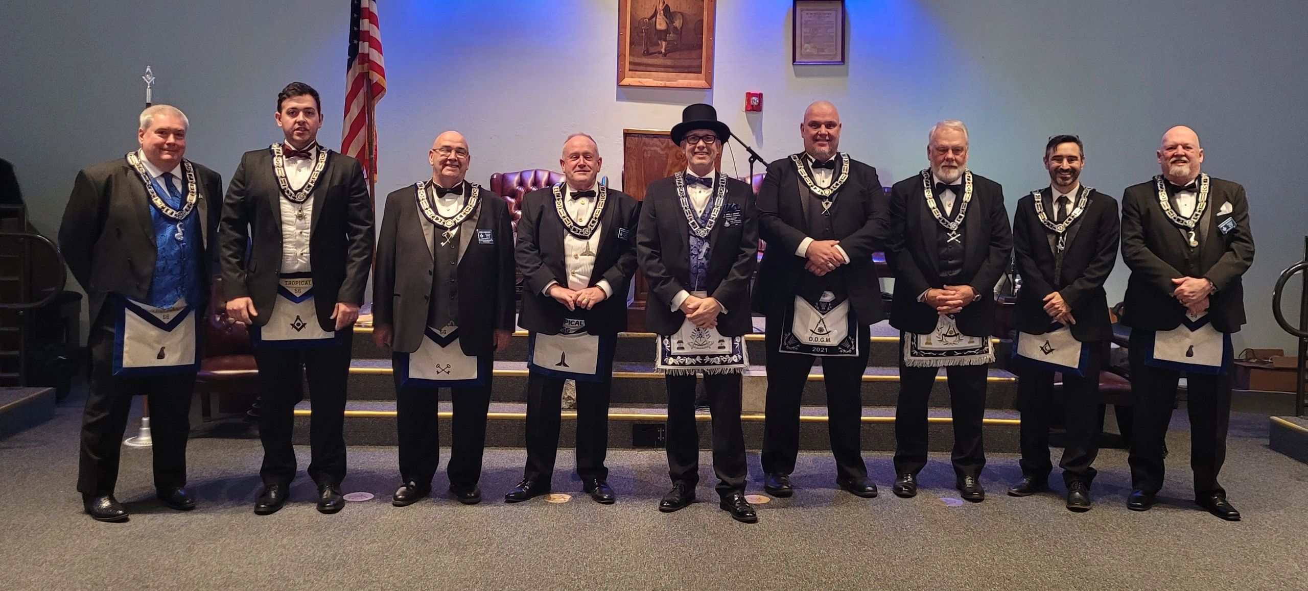 Group of men in formal Masonic attire posing inside a lodge.