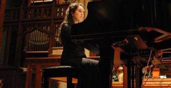 Ms. Bea plays the piano at a benefit concert.