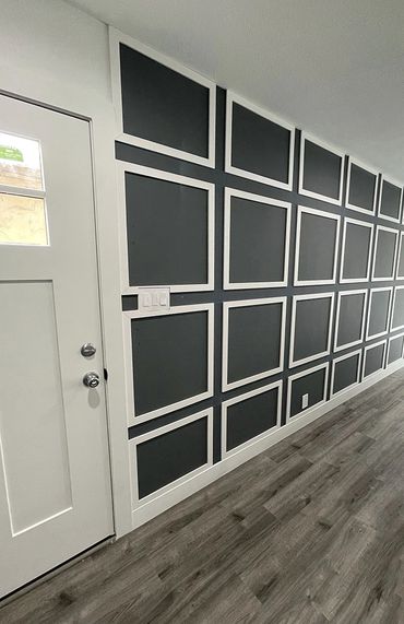 grey hardwood floors, black painted wall with white squares