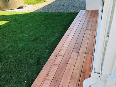 Artificial grass near wooden backyard porch