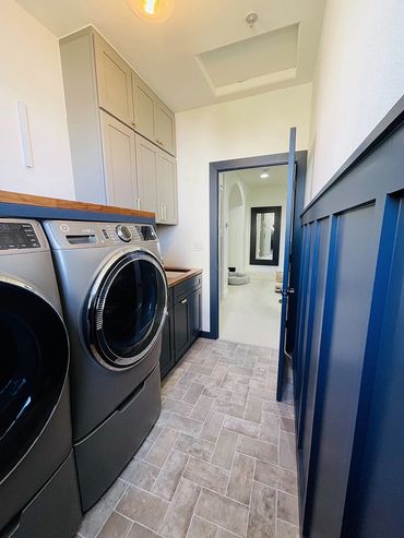 Newly remodeled laundry room, washer and dryer, dark blue wooden walls