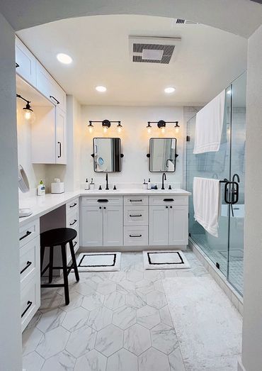 Bathroom remodeled by Top Line Remodeling Inc. Two sinks, two mirrors, white cabinets, black handles