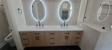 brown vanity, two oval mirrors, two sinks