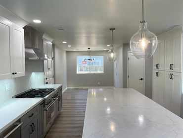 kitchen renovation photo, kitchen island with gray cabinets, stove, window on the back