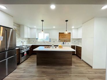 photo of the kitchen that has a kitchen island with brown textured bottom