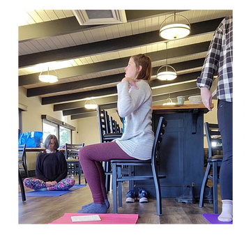 three women. one on a yoga mat on the floor, one sitting on a chair, one standing