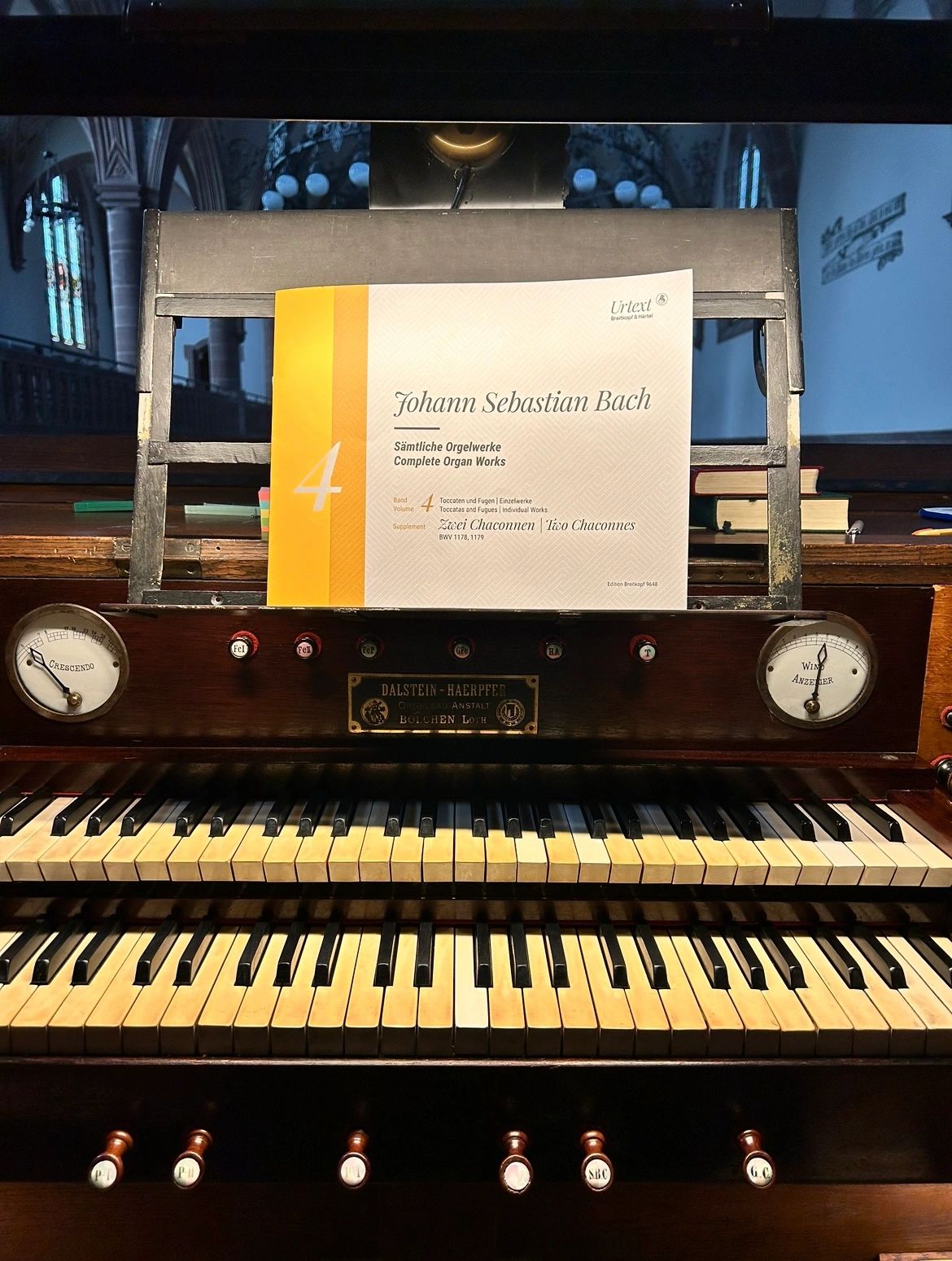 An old organ keyboard with Johann Sebastian Bach sheet music.