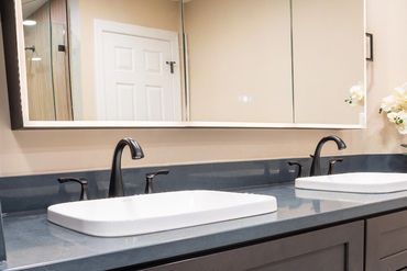 Modern bathroom vanity with dual sinks and dark cabinetry.