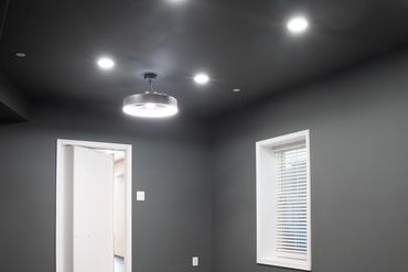 Empty modern room with dark walls and tile flooring.