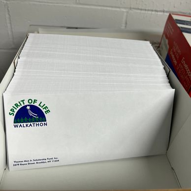Stack of white custom printed envelopes with nonprofit organization logo and return address printed 