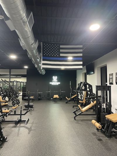 Modern gym with workout equipment and a thin blue line flag.