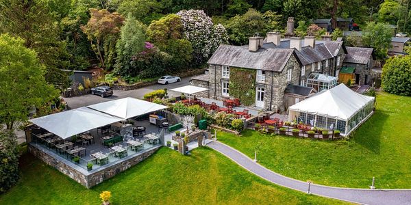 Charming Aberdunant Hall with outdoor seating and lush greenery.