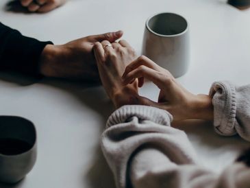 Holding hands and with cups.