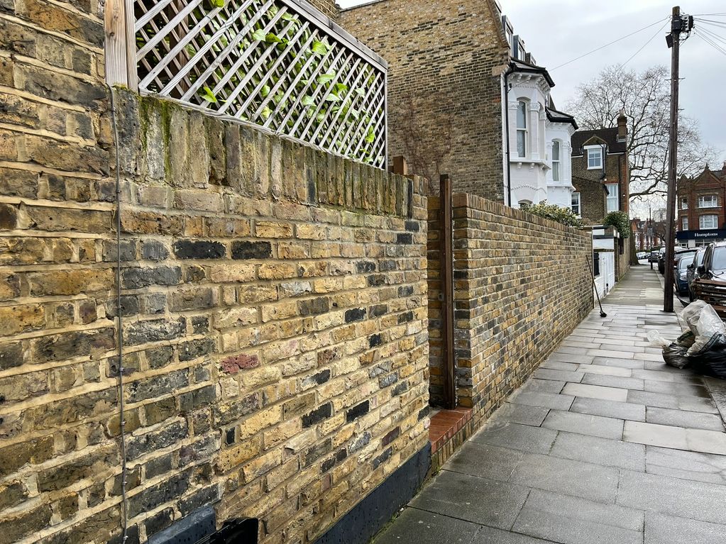 Rebuilt front garden wall, new foundation, reclaimed bricks and pointing in Parsons Green.