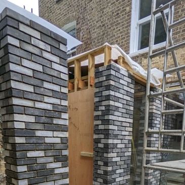 a modern design house extension built of light grey and black engineering bricks in London