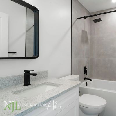 Bathroom with grey tiles and matte black hardware