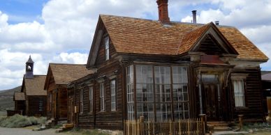 Old wooden house with a small fenced yard.