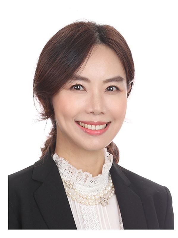 Professional woman smiling, dressed in business attire.