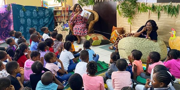 Teacher reading to attentive children in a vibrant classroom.