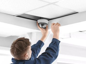 man installing security camera