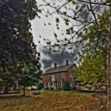 Old brick house with cloudy sky and trees.