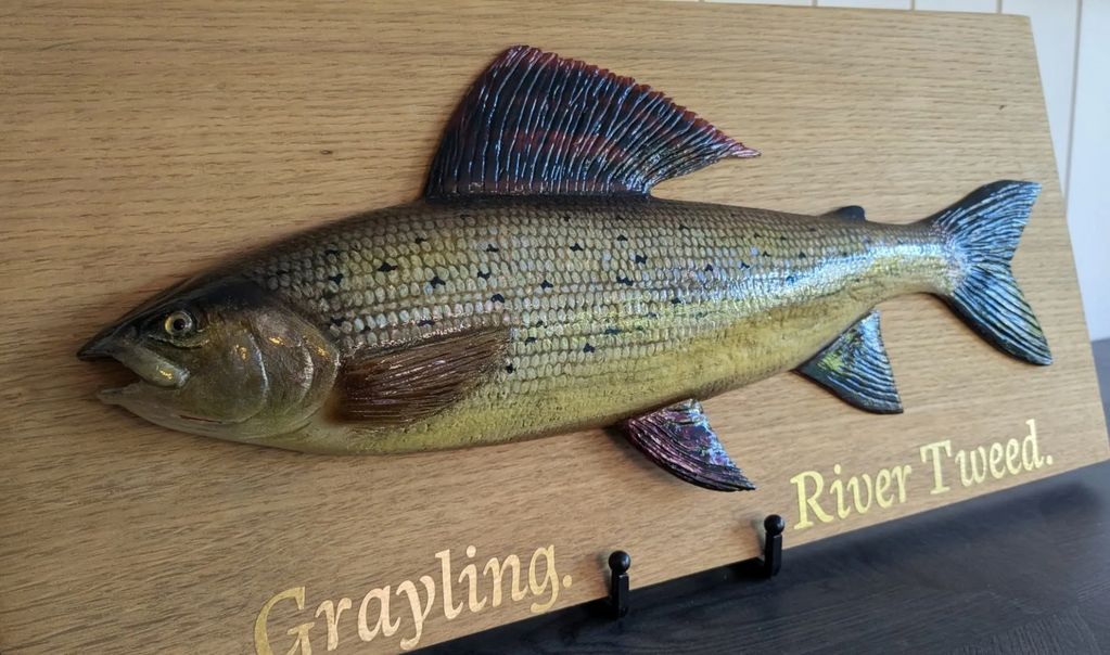 Close-up image of wood carving of a grayling.
