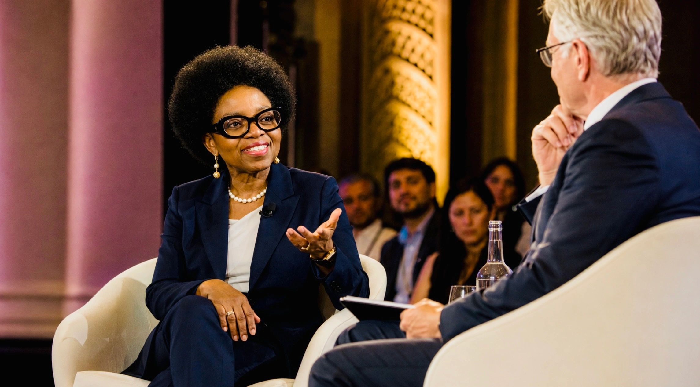 Two people in a formal conversation during an event.