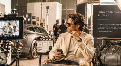 Man on a film set holding a phone.