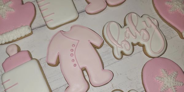 Pink and white baby-themed decorated cookies.