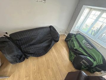 Two deflated air sofas in a room with wooden floor.