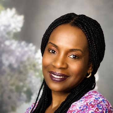 Smiling woman with braided hair and floral top.