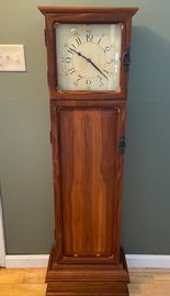 This small grandfather clock is made of Black Walnut and stands about 5 1/2' tall. Behind the raised