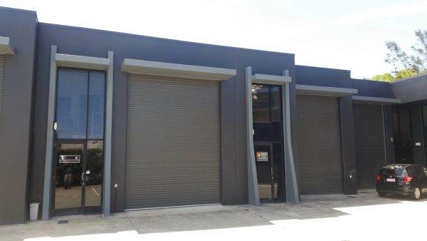 Modern industrial building with closed roller shutter doors.