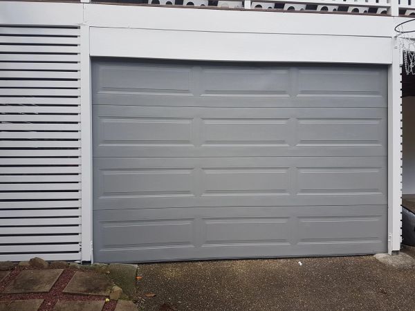 Closed gray garage door on a house.