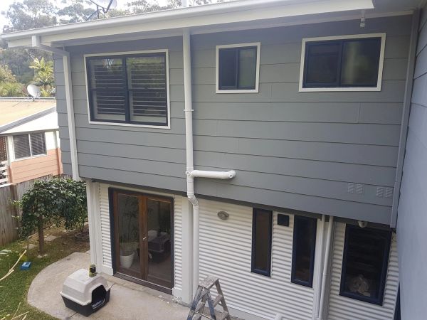Modern two-story house exterior with multiple windows.