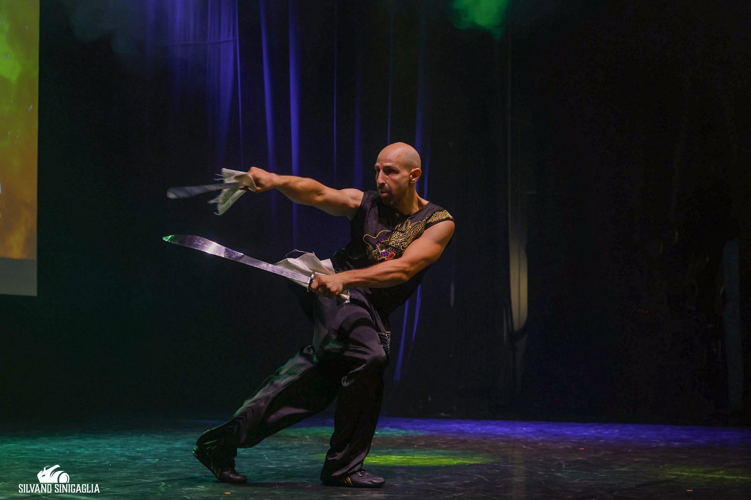Uomo che balla con nastri metallici sul palco.